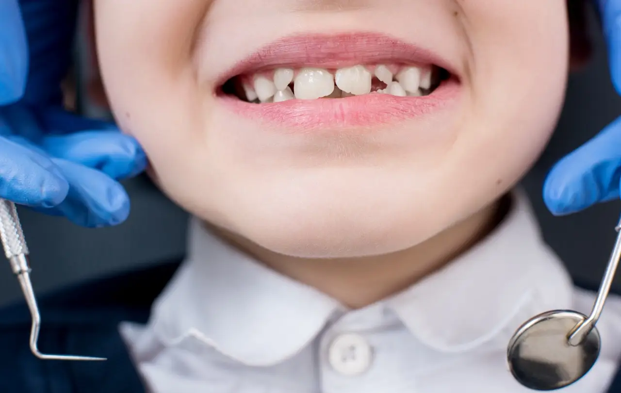 Female dentist examines the teeth of the patient child